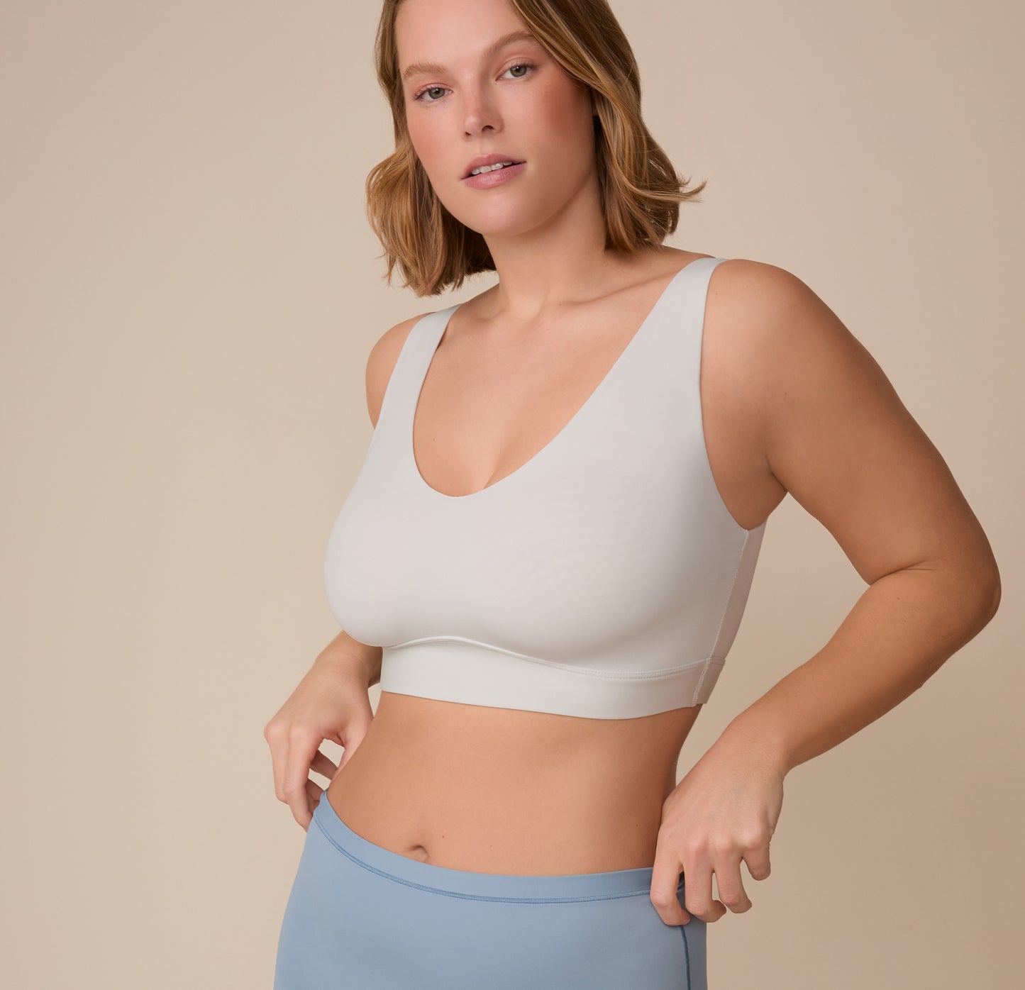 Three-quarter front view of Sonnie wearing the Bliss Bralette in Frost, showcasing the bralette’s comfortable fit and wide underband.
