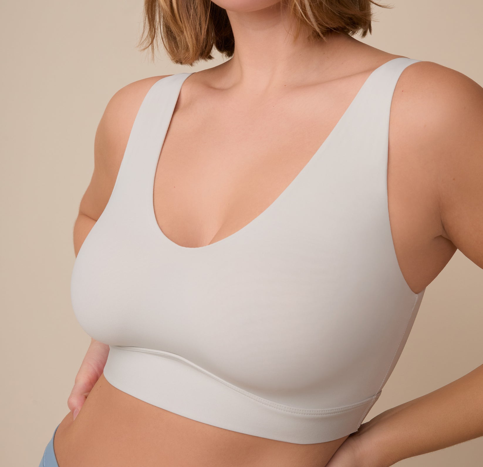 Angled close-up of Sonnie in the Bliss Bralette in Frost. The image highlights the smooth fabric and low scoop neckline, designed for everyday ease and comfort.