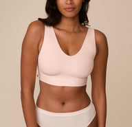 Front view of Victoria wearing the Bliss Bralette in Rose. The soft V neckline and wide straps offer a smooth fit with minimal seams and a supportive underband. sizing: Victoria wears size Medium