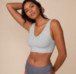 Victoria stands in a relaxed pose wearing the Bliss Bralette in Stormy. The angled view highlights the bralette’s sculpted bust and ultra-soft fabric.