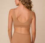 Back view of Freya wearing the Bliss Bralette in Tan. The image shows the bralette’s scoop back and supportive band that lays flat against the skin.