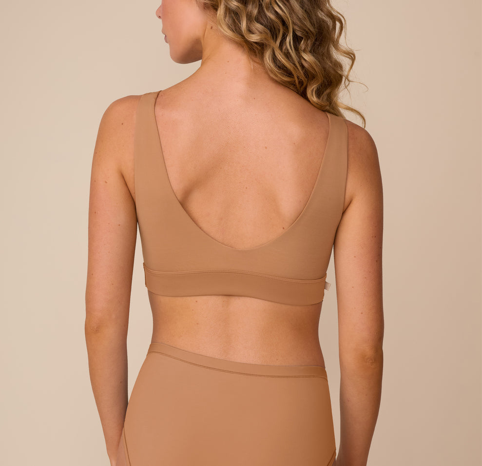 Back view of Freya wearing the Bliss Bralette in Tan. The image shows the bralette’s scoop back and supportive band that lays flat against the skin.