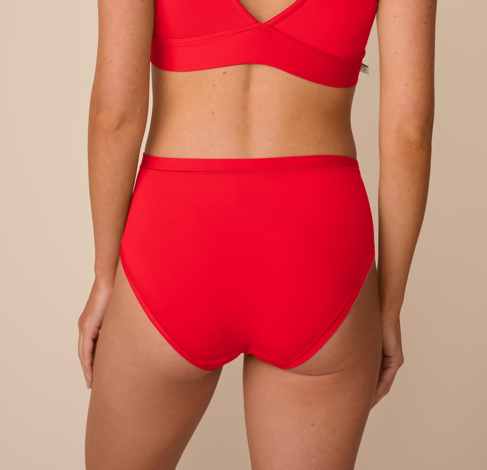 Back view of Freya wearing the Bliss Highwaist Brief in Cherry. The image shows the full-coverage design and flat leg seams that minimize panty lines.
