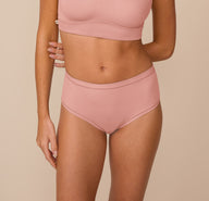 sizClose-up of Freya wearing the Bliss Highwaist Brief in Dusty Rose. The brief sits at the natural waist and features Harper Wilde’s soft microfiber fabric with elastic-free edges for all-day comfort. sizing: Freya wears size Small