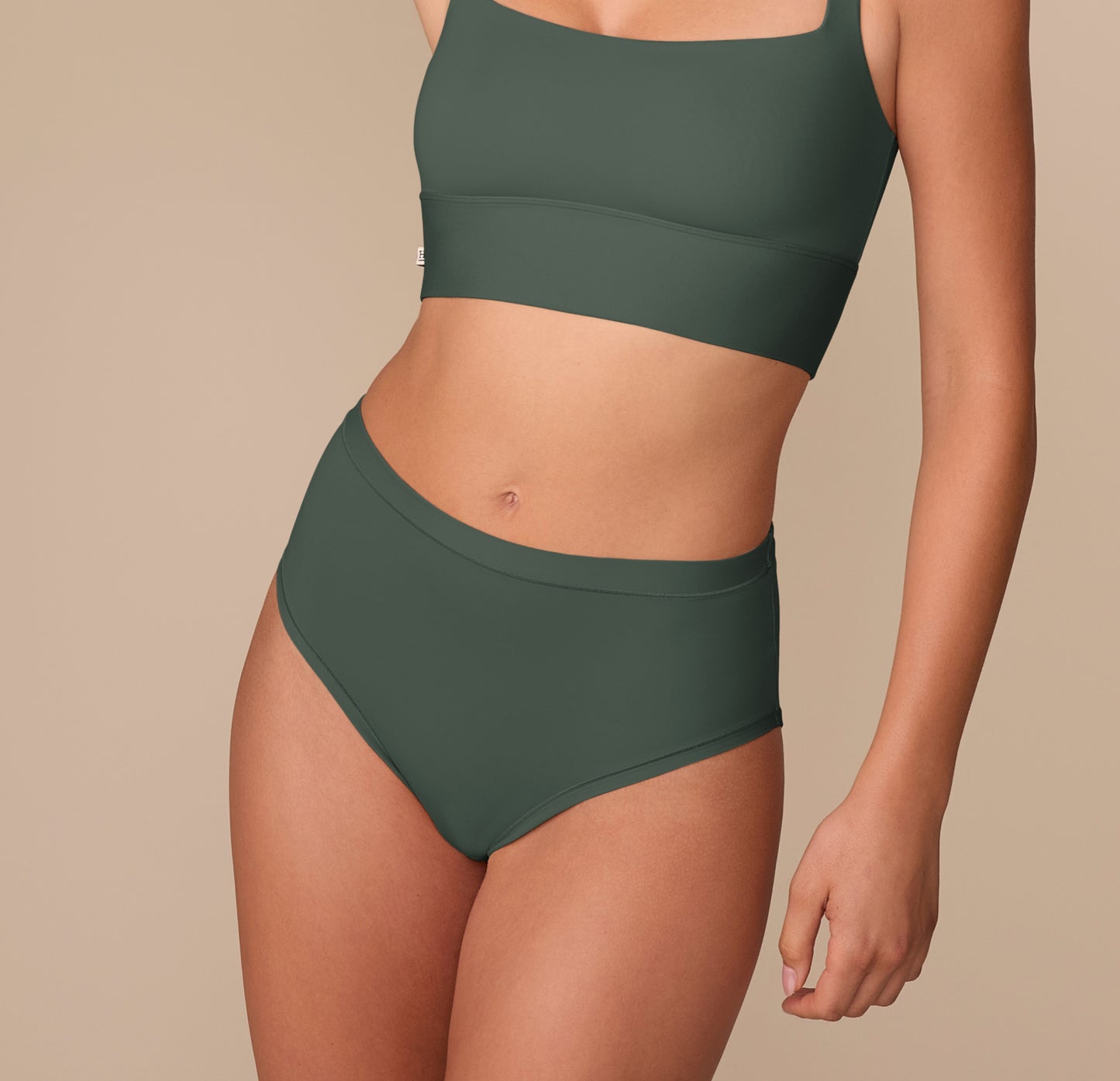 Alexis wearing the Bliss Highwaist Brief in Fir, front view, with a smooth waistband and full coverage. sizing: Alexis wears size Small