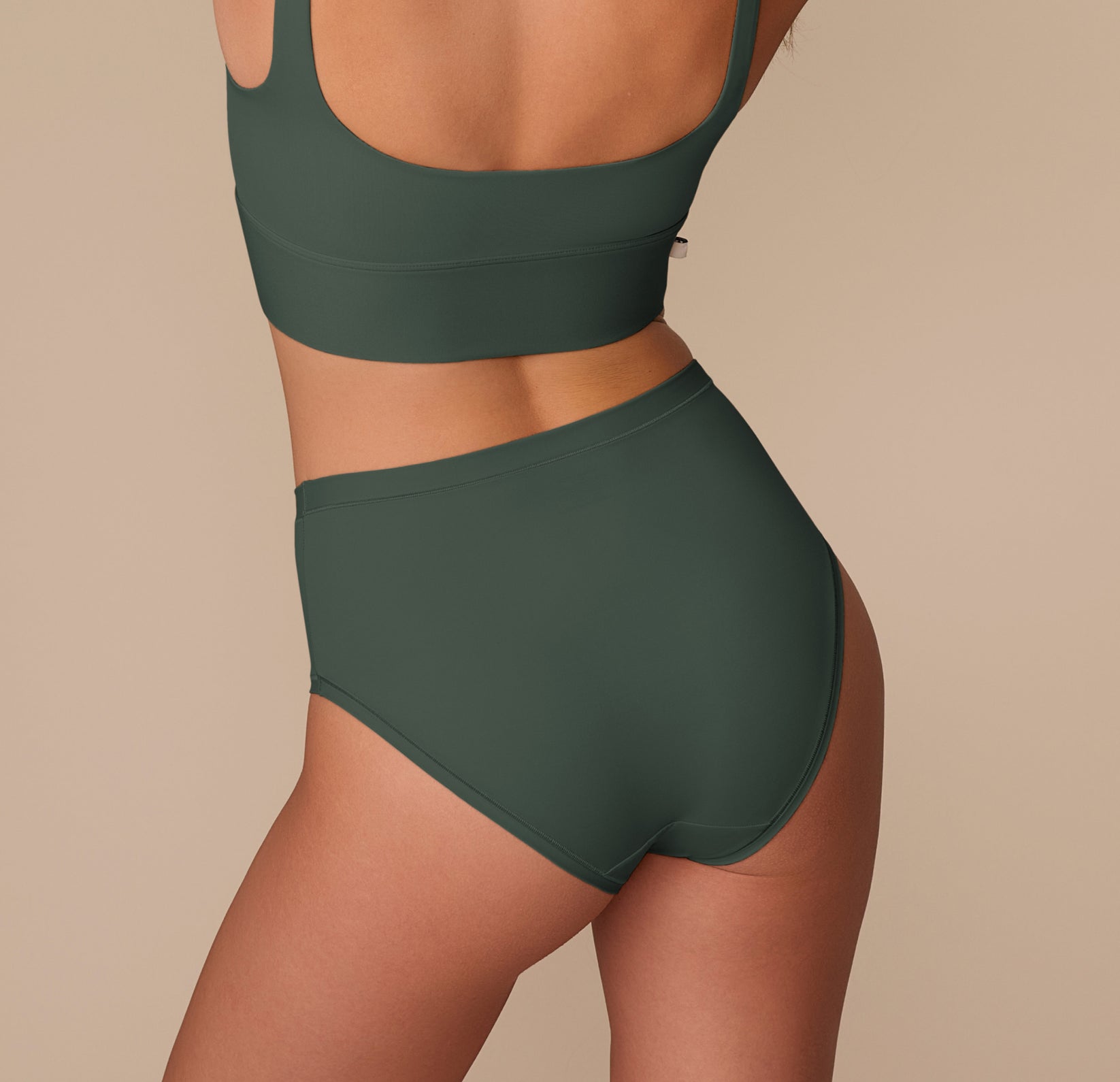 Back view of Alexis in the Bliss Highwaist Brief in Fir, showing the comfortable fit and moderate rear coverage.