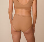 Back of Freya wearing the Bliss Highwaist Brief and the Bliss Bralette in Tan. The full coverage back and comfortable seams are emphasized.