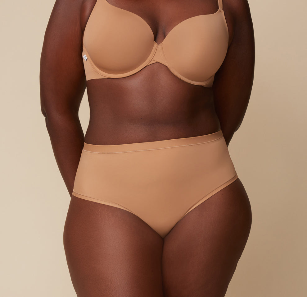 Akesha wearing the Bliss Highwaist Brief and Base T-Shirt Bra in Tan. The high rise waistband and microfiber material are emphasized. sizing: Akesha wears size XL
