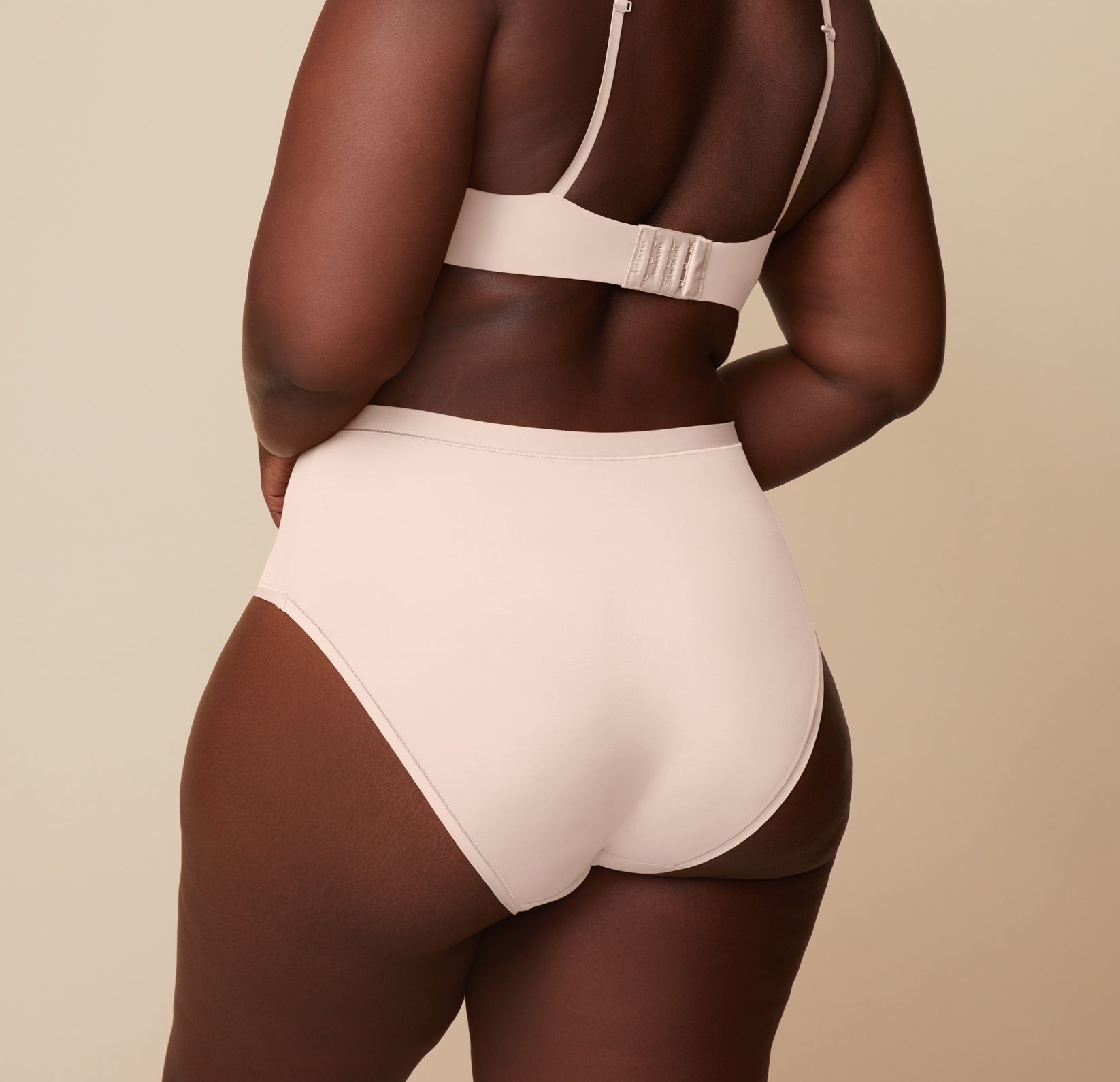 Back view of model Akesha in the Base T-Shirt Bra and Bliss Highwaist Brief in Rose, showcasing the supportive and comfortable high-waisted design of the brief.