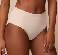 Close-up of Ally wearing the Bliss Highwaist Brief in Rose, focusing on the soft fabric and comfortable, high-rise fit of the brief. 