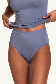 Close-up of Courtney wearing the Bliss Highwaist Brief in Steel with a matching Steel tank, highlighting the smooth high-rise waistband and soft microfiber fabric.