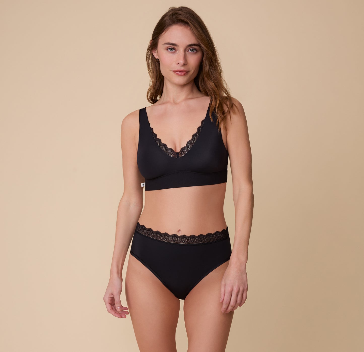 Gracie wears the Bliss Lace Highwaist Brief in Black, paired with the matching Bliss Lace Bralette in Black. The lace trim and soft, seamless design create a cohesive, comfortable set.