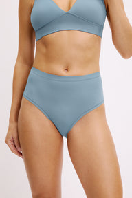 On a white studio backdrop, Darion wears the Bliss Highwaist brief in Poolside with the matching Bliss Triangle Bralette, shown from the front to highlight the smooth microfiber fabric and high-rise waistband. sizing: Darion wears size Small