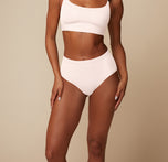Close-up of Ally wearing the Bliss Scoop Bralette and Highwaist Brief in Quartz. The smooth finish and comfortable, highwaisted fit is highlighted. 