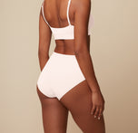 Back view of Ally wearing the Bliss Scoop Bralette and Bliss Highwaist Brief in Quartz. The brief's full coverage and smooth finish are highlighted. 