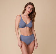 Gracie wears the Bliss Highwaist Brief in Steel paired with the matching Base Unlined Bra, posing confidently against a neutral backdrop.
