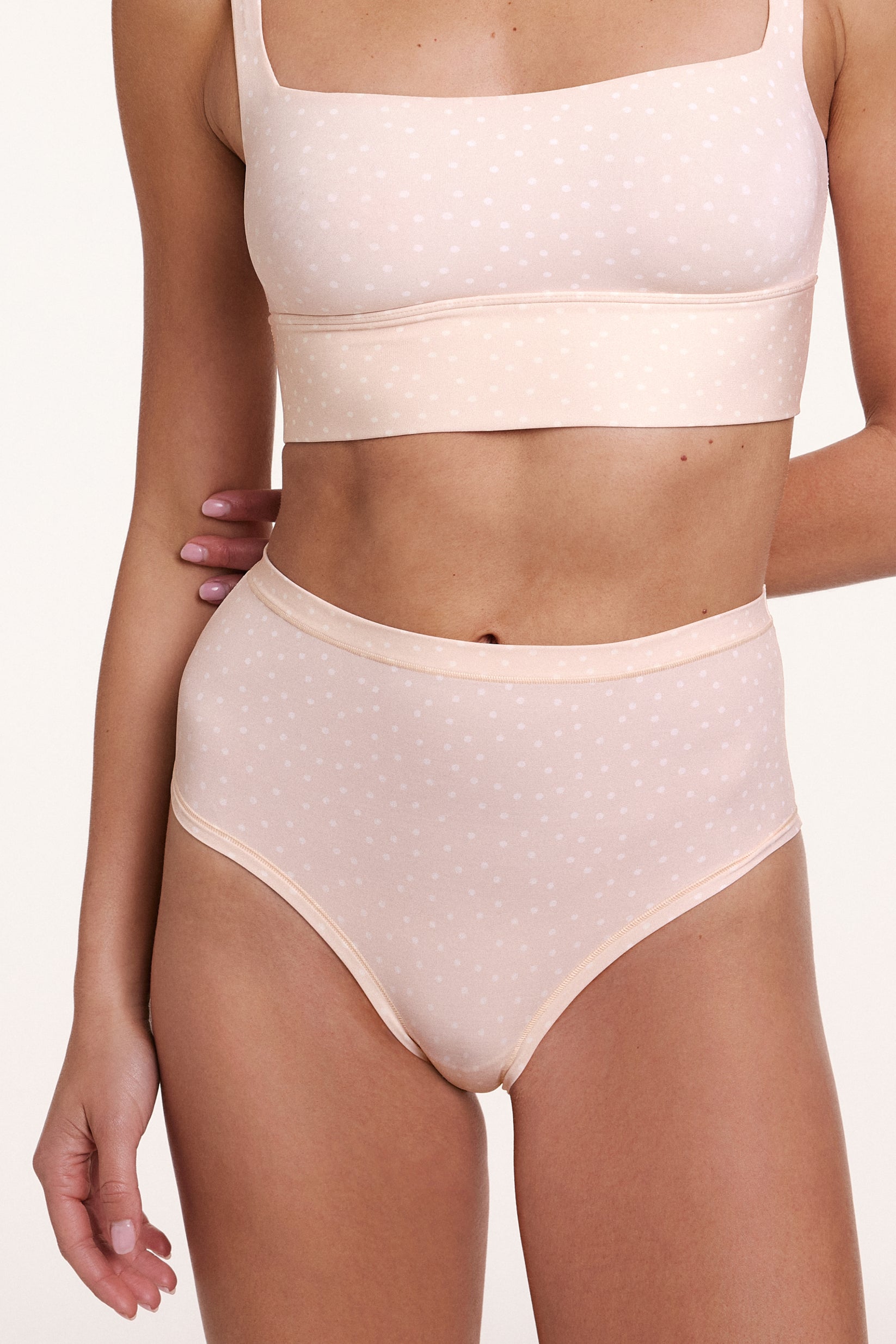 In a studio close-up, Gianna wears the Bliss Highwaist Brief in Champagne Fizz with the Bliss Square Neck Bralette in Champagne Fizz, showing the high-rise waistband, full coverage design, and soft microfiber fabric with a subtle dotted pattern. sizing: Gianna wears size Small