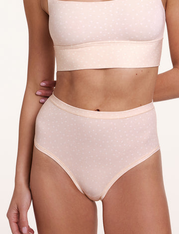 In a studio close-up, Gianna wears the Bliss Highwaist Brief in Champagne Fizz with the Bliss Square Neck Bralette in Champagne Fizz, showing the high-rise waistband, full coverage design, and soft microfiber fabric with a subtle dotted pattern. sizing: Gianna wears size Small
