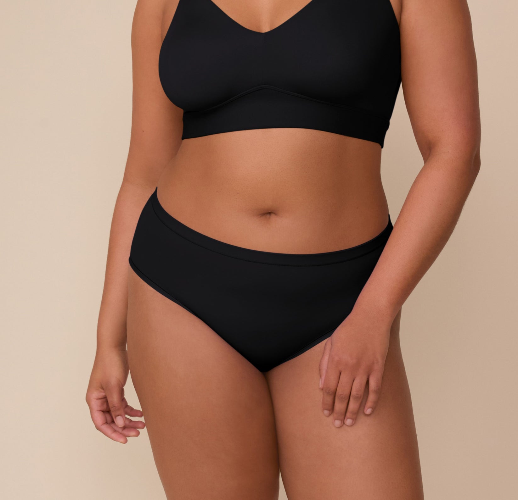 Close-up front view of Zarria wearing the Bliss Hiphugger in Black. The image shows the supportive and smooth fit across the midsection, with no bunching or pinching. sizing: Zarria wears size XL