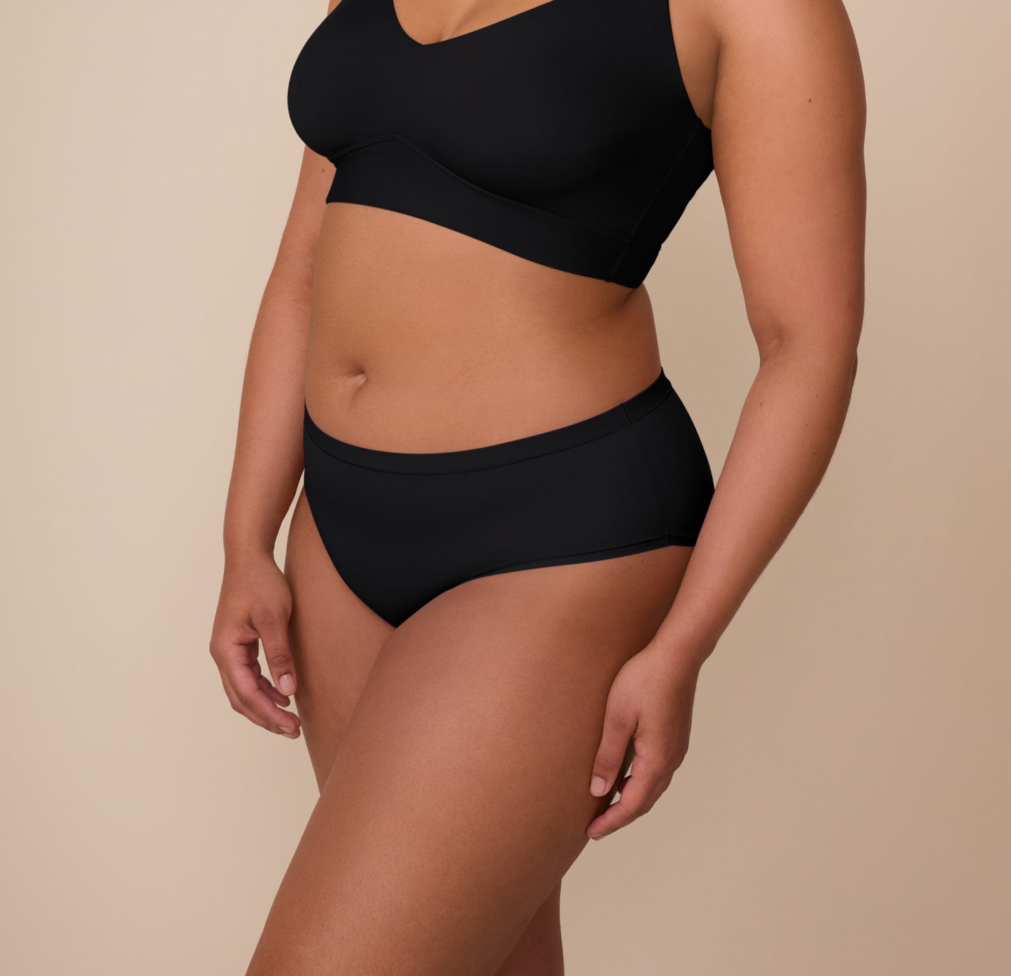 Angled side view of Zarria in the Bliss Hiphugger in Black. The wide-cut leg openings and ultra-soft finish are visible, emphasizing all-day comfort.