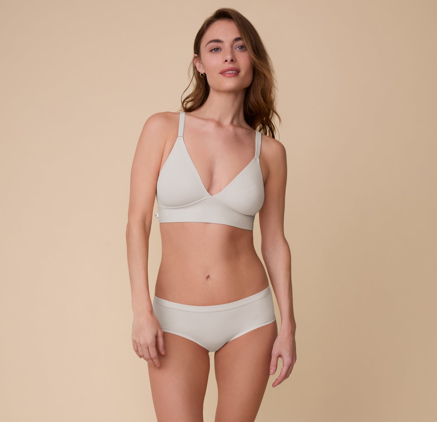 Full-body view of Gracie wearing the Bliss Triangle Bralette and Bliss Hiphugger in Frost. The bralette and hiphugger set showcases a soft, lightweight design made for everyday comfort.