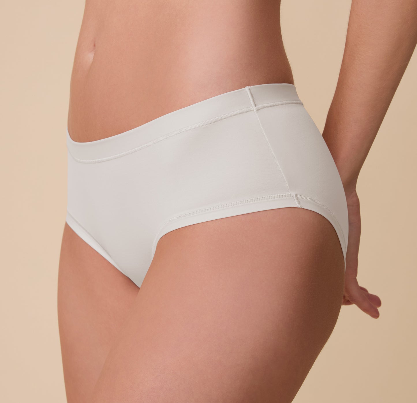 Side view of Gracie in the Bliss Hiphugger in Frost, highlighting the smooth microfiber fabric and full-coverage fit designed to stay in place.