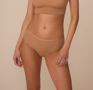 Marcela is shown from the front wearing the Bliss Hiphugger paired with the Bliss Bralette in Tan. The hiphugger sits low on the waist with a smooth waistband and moderate coverage for a clean, flattering fit. sizing: Marcela wear size Small