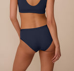 Back view of Marcela wearing the Bliss Hiphugger in True Blue. The image showcases full back coverage and a sleek, no-dig fit.