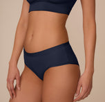 Side profile of Marcela in the Bliss Hiphugger in True Blue. The image highlights the smooth leg openings and seamless construction designed for invisible wear under clothes.