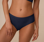 Close-up of Marcela wearing the Bliss Hiphugger in True Blue. The image captures the flat waistband and smooth, barely-there fabric ideal for everyday wear.