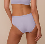 Back view of Marcela in the Bliss Hiphugger in Violet, highlighting the full rear coverage and minimal seam construction that creates a no-show effect under clothing.