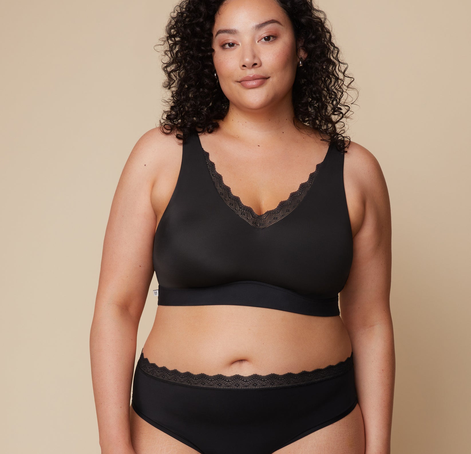 Bianca models the Bliss Lace Bralette in Black, highlighting its supportive yet flexible fit with lace detailing. sizing: Bianca wears size XL