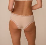 Back view of Marcela in the Bliss Lace Cheeky Brief in Beige. The image showcases the cheeky rear coverage and flat-lying lace for a smooth, no-pinch finish.