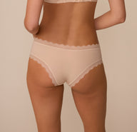 Back view of Marcela in the Bliss Lace Cheeky Brief in Beige. The image showcases the cheeky rear coverage and flat-lying lace for a smooth, no-pinch finish.