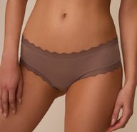 Close-up front angled view of Marcela wearing the Bliss Lace Cheeky Brief in Mauve, showing the smooth microfiber fabric and lace trim with a focus on comfort and everyday wearability.