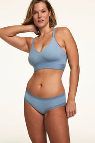 On a white studio backdrop, Sonnie wears the Bliss Lace Cheeky in Poolside with a matching Poolside bralette. The cheeky silhouette and soft lace trim are shown with smooth microfiber fabric and moderate back coverage.  sizing: Sonnie wears size Large