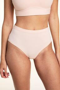 In a studio setting, Laura wears the Bliss Lace Highwaist Brief in Rose, featuring a high-rise silhouette, smooth microfiber fabric, and clean bonded edges with full front coverage.