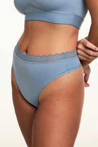 Close-up of Sonnie wearing the Bliss Lace Highwaist Thong in Poolside with a matching Poolside bralette, highlighting the high-rise silhouette, smooth microfiber fabric, and soft lace waistband.  sizing: Sonnie wears size Large