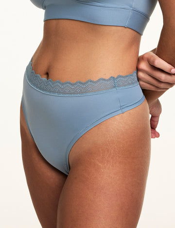 Close-up of Sonnie wearing the Bliss Lace Highwaist Thong in Poolside with a matching Poolside bralette, highlighting the high-rise silhouette, smooth microfiber fabric, and soft lace waistband.  sizing: Sonnie wears size Large