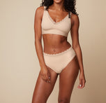 Model Ally wearing the Bliss Lace Highwaist Brief in Beige, paired with the Bliss Lace Bralette. She stands facing forward, highlighting the comfortable, full-coverage fit of the highwaist brief and the soft, supportive bralette.