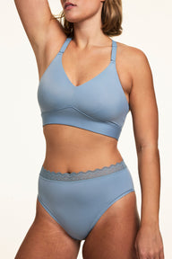 On a white studio backdrop, Sonnie wears the Bliss Lace Highwaist in Poolside with a matching Poolside bralette, highlighting the high-rise silhouette, smooth microfiber fabric, and soft lace waistband.  sizing: Sonnie wears size Large
