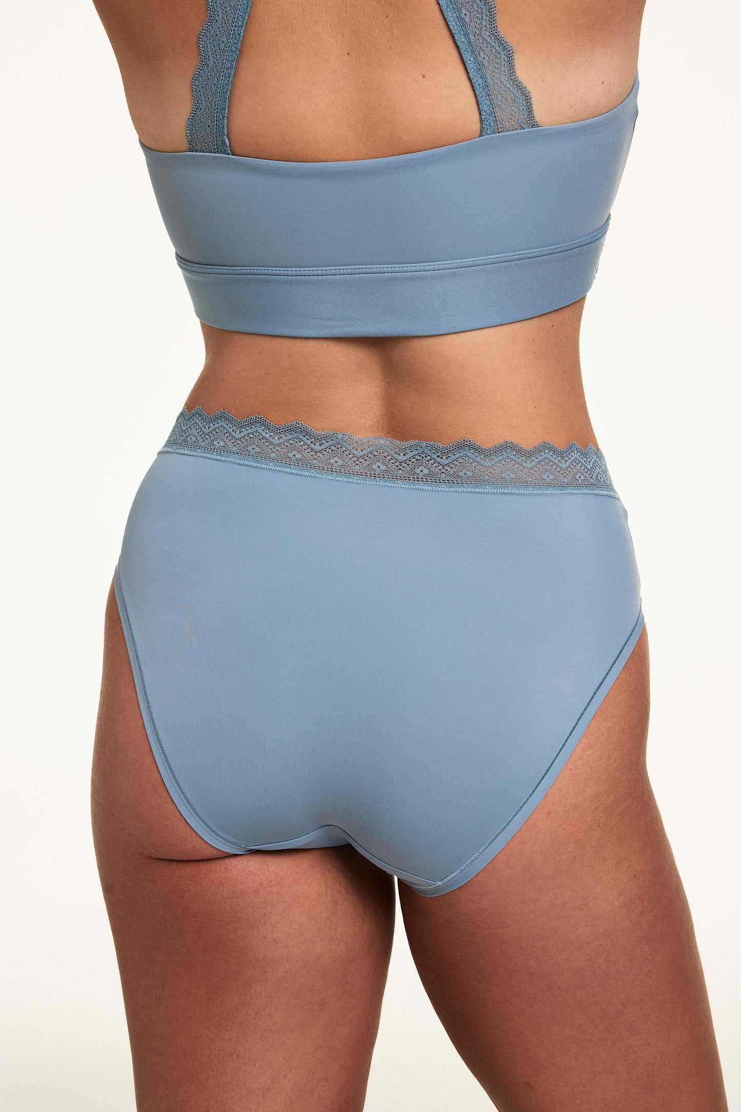 Back view of Sonnie wearing the Bliss Lace Highwaist in Poolside with a matching Poolside bralette, showing the lace waistband detail and full back coverage.