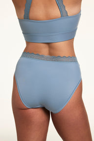 Back view of Sonnie wearing the Bliss Lace Highwaist in Poolside with a matching Poolside bralette, showing the lace waistband detail and full back coverage.