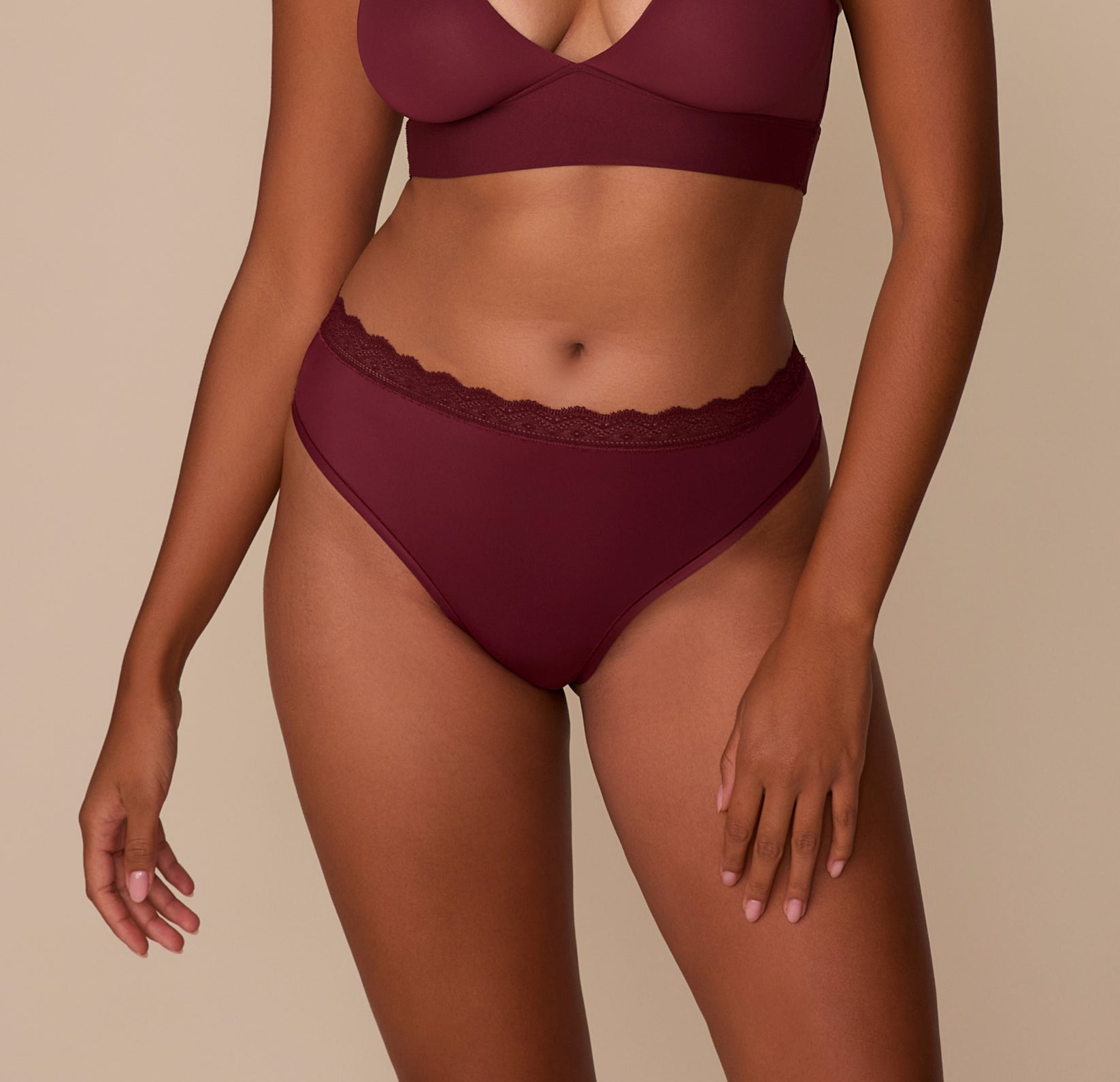 Model Victoria wears the Bliss Lace Highwaist Thong in Bordeaux. The front view highlights the ultra-soft microfiber fabric and lace-trimmed waistband designed to sit comfortably at the natural waist. sizing: Victoria wears size Medium