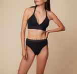Anna posing in the Bliss Lace Thong in Black, paired with the Bliss Lace Halterneck Bralette. The image captures a front view, focusing on the thong’s lace waistband and high-rise design.