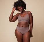 Akesha smiling while wearing the Bliss Lace Halterneck Bralette and matching Bliss Lace Highwaist Brief in Mauve. The image highlights the bralette’s halterneck design and the highwaisted fit of the brief, emphasizing comfort and style.
