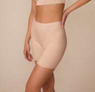 Side angle of Marcela in the Bliss Under Short in Beige, focusing on the seamless lines and soft stretch waistband for everyday comfort.