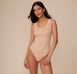 Full-body view of Marcela in the Bliss Tank and Bliss Thong in Beige. She stands confidently, showing the lightweight layering tank’s soft drape.
