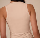 Detail view of the back of Marcela wearing the Bliss Tank in Beige, focusing on the wide straps and minimal seam stitching for a comfortable fit.