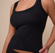Close-up of Sonnie wearing the Bliss Tank in Black, emphasizing the wide neckline, smooth fabric, and snug fit.